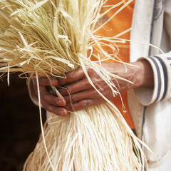 Hands holding a bundle of natural raffia