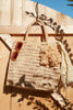 Georgia tote in Natural with sunglasses and a towel on a wooden fence