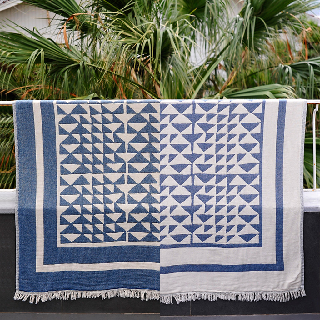 Hand woven Turkish cotton throw in marine and white hanging on a railing - photoshopped to show both sides
