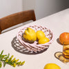 Ceramic pink basket with lemons on table