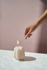 White sculptural candle being lit
