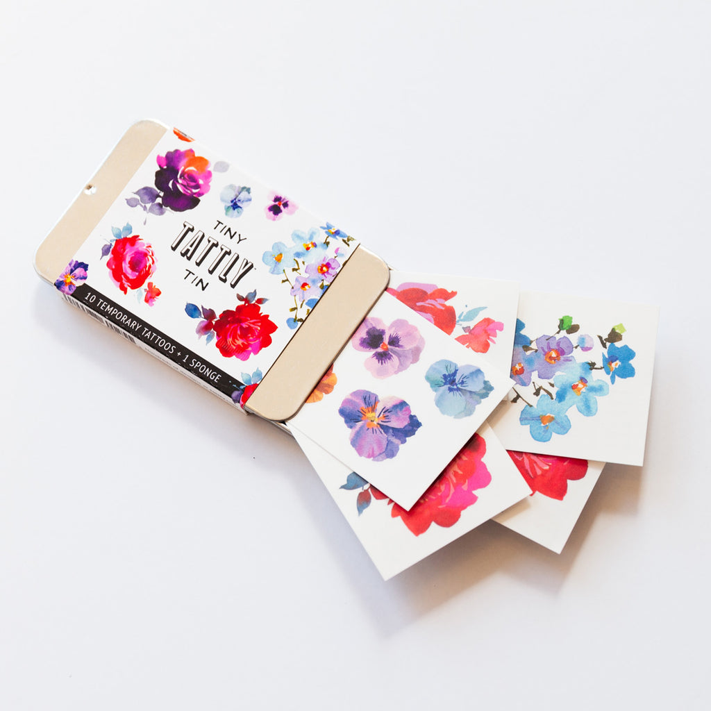 Tiny tin of floral tattoos package open with tattoos arranged