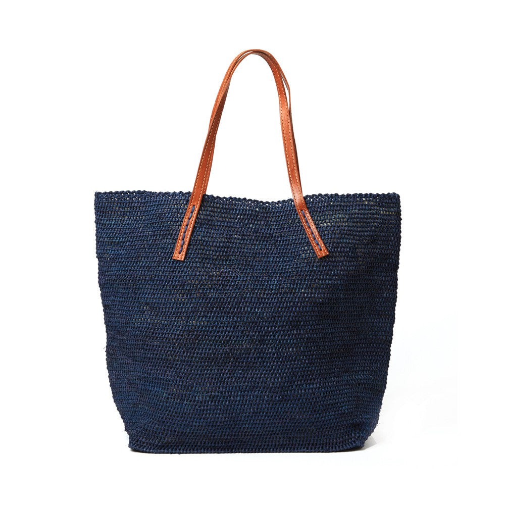 Navy colored crocheted carryall with snap closure, cotton lining & leather straps