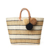 Sand and natural striped woven sisal basket tote with pom poms and leather handles