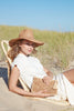 Model sitting on beach with Ellie Sand