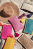 Assortment of Ellie pouches and a hat on the sand