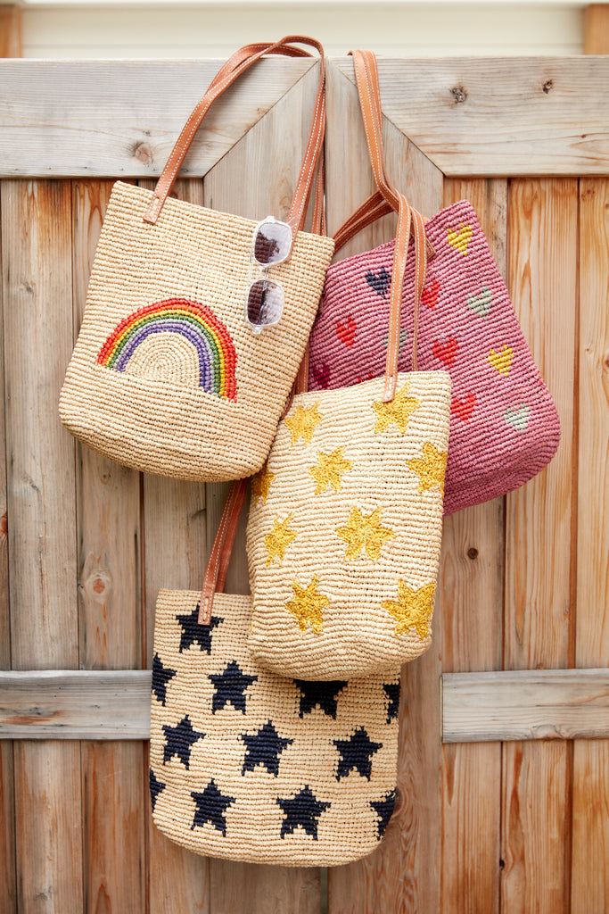 Four kids totes hanging on a wooden door