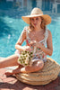 Model sitting near a pool holding Lilith Emerald