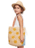 Avery Natural hat, woven Soleil tote bag with star patterns held by a person