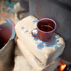 Natural dye in a cup on top of bricks