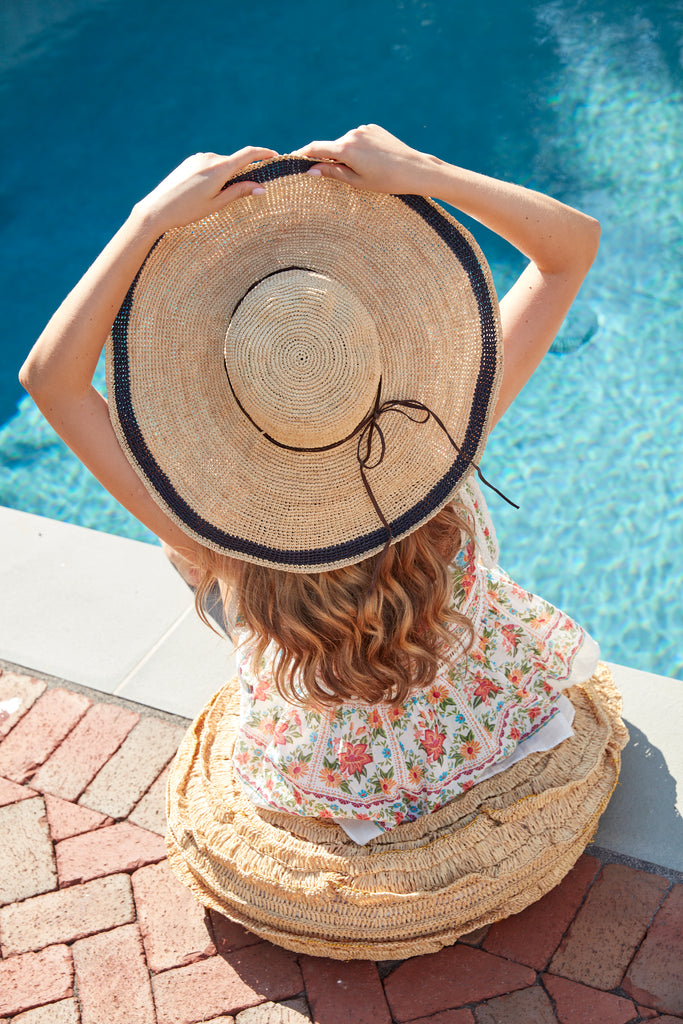 Model sitting poolside wearing Tori Navy