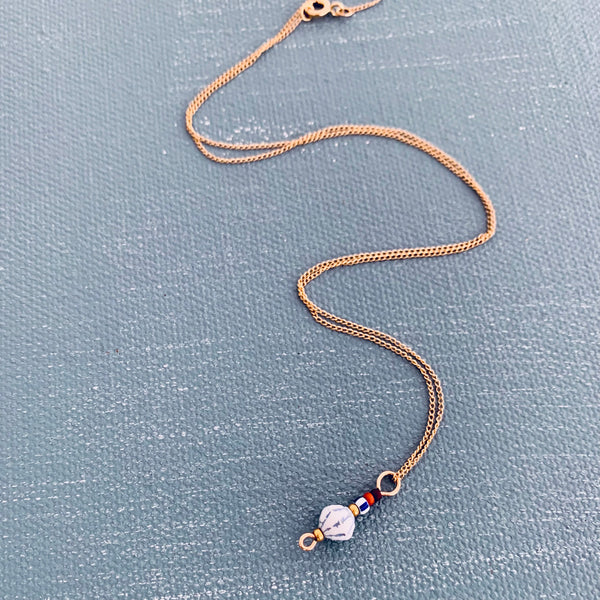 Float Necklace displayed on a blue painted surface