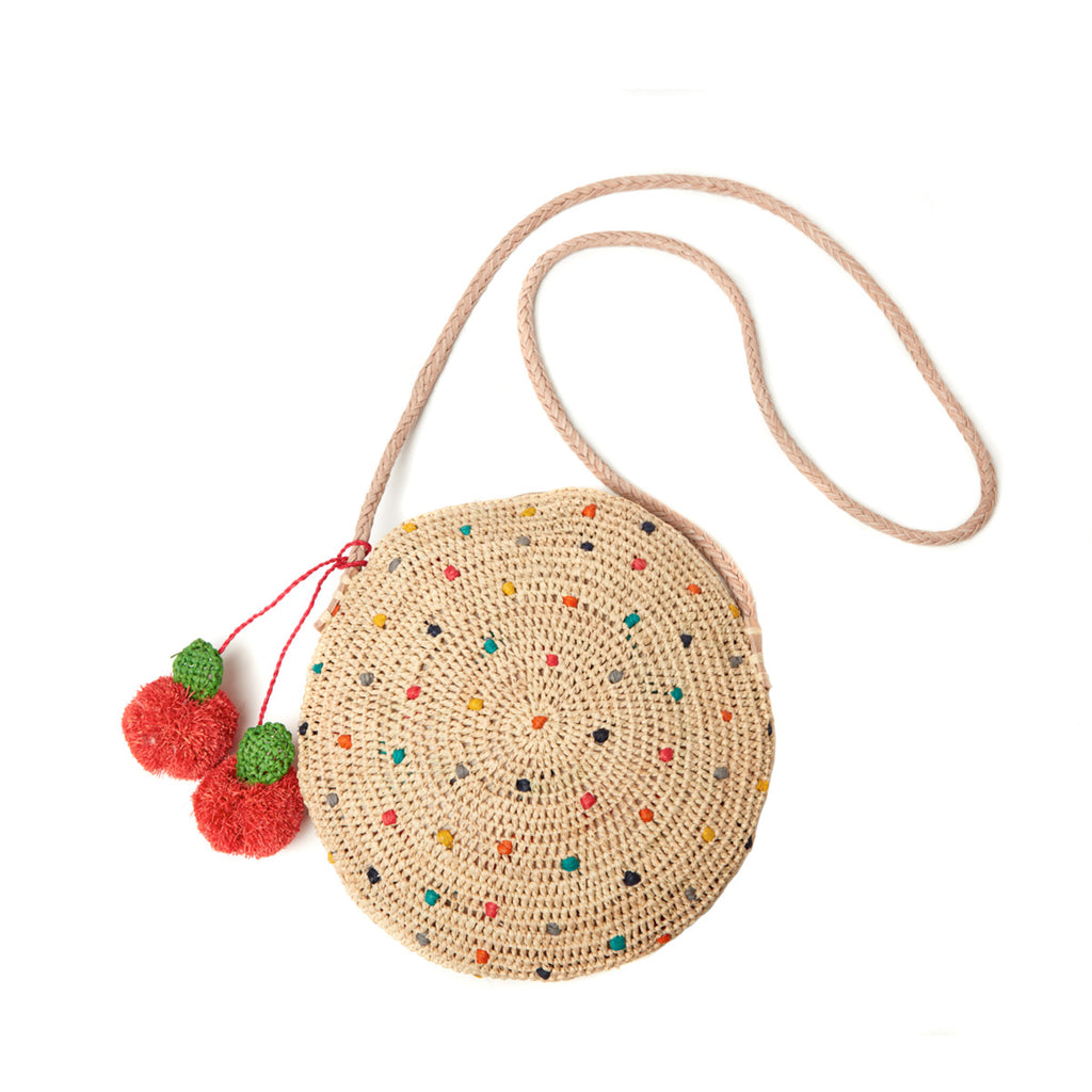 Multi colored polka dot shoulder bag with cotton lining, leather strap, and cherry pom poms