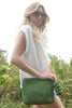 Crop of model holding Antonia in Emerald with grassy background behind her