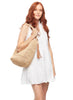 Model holding natural colored crocheted raffia shoulder bag with leather tassel & snap closure