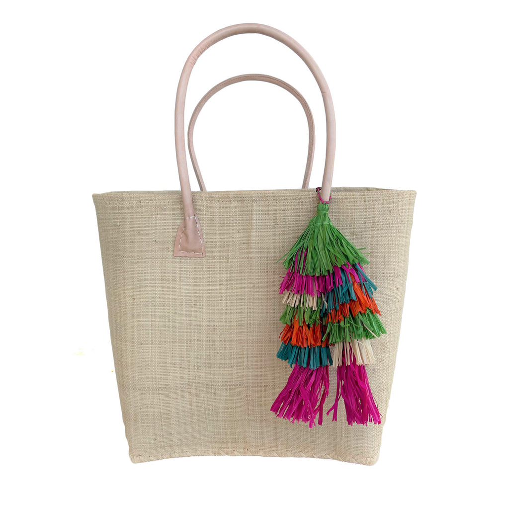 Natural colored woven seagrass and sisal tote with leather handles and multi colored tassel.