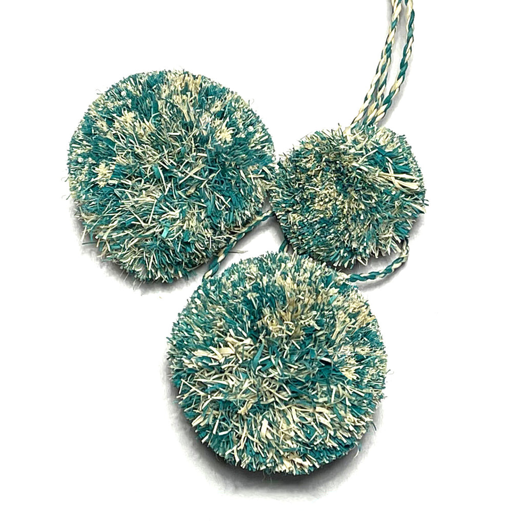 Mottled aqua and natural colored pompoms as used on the Caracas tote