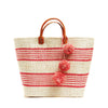 Coral colored woven sisal basket tote with pom poms & leather handles