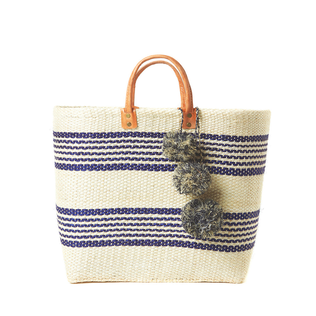 Navy colored woven sisal basket tote with pom poms & leather handles