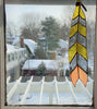 Stained glass feather with grey, yellow, and pink panes hanging from leather tie in window