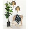 Pair of Bolga Fans in Black on a White Wall next to a wooden chair and potted plant