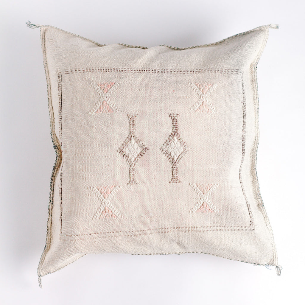Cream colored square pillow with embroidered design