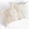 Two cream colored square pillow with embroidered design