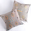 Two dove colored square pillow with embroidered design