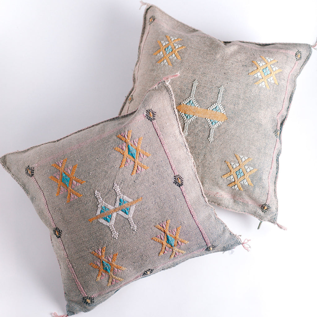 Two dove colored square pillow with embroidered design
