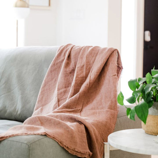 Woven linen throw in stonewashed rose on a sofa