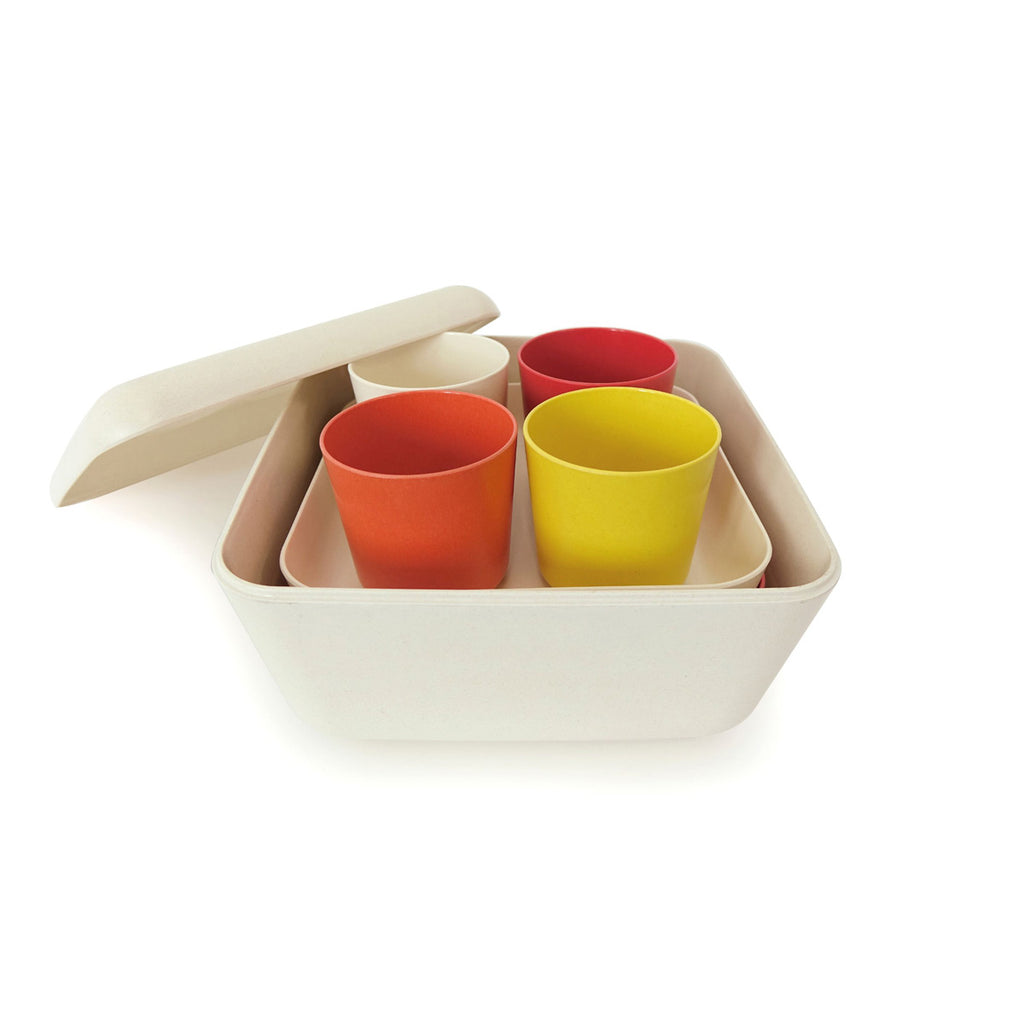 Orange, white, and yellow plates and cups and trays stacked in case with lid 