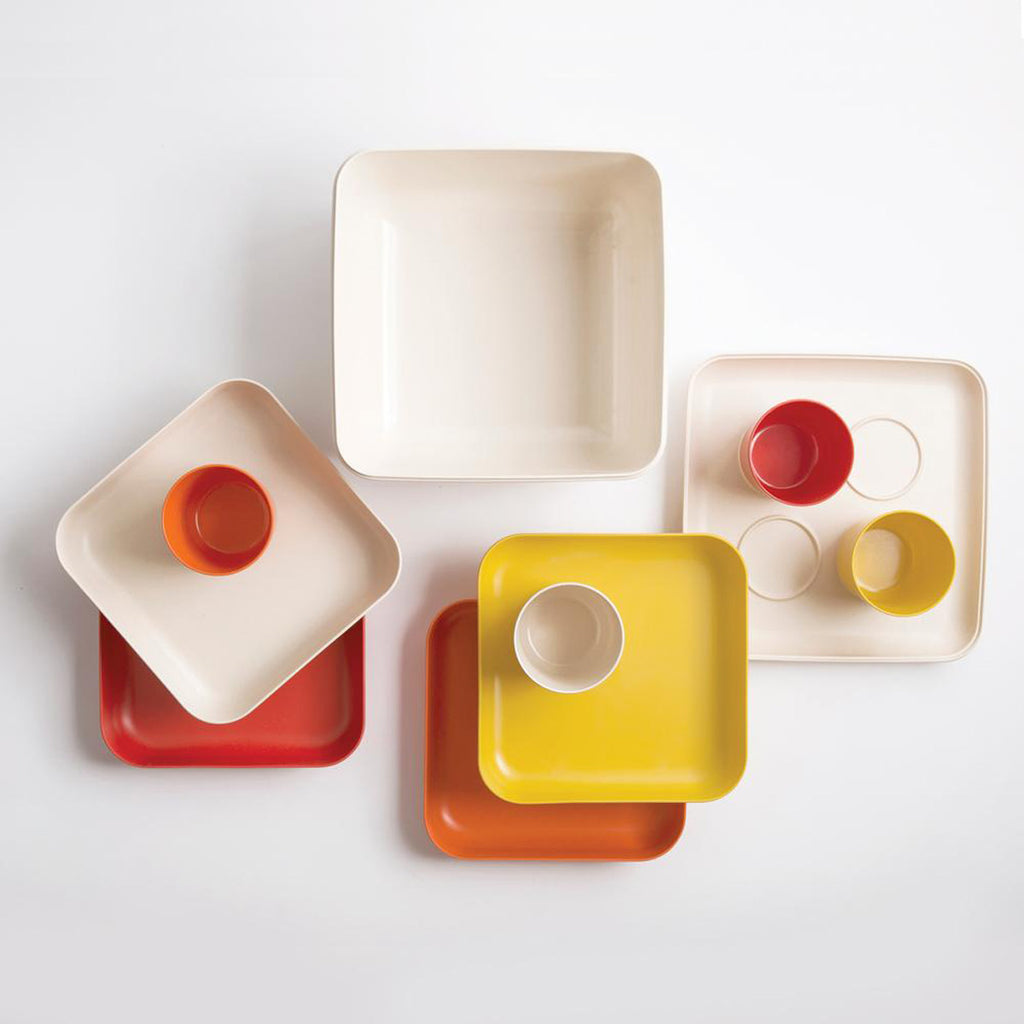 Orange, white, and yellow plates and cups and trays