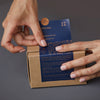 hands placing Even Keel label on a box of six bath fizzies
