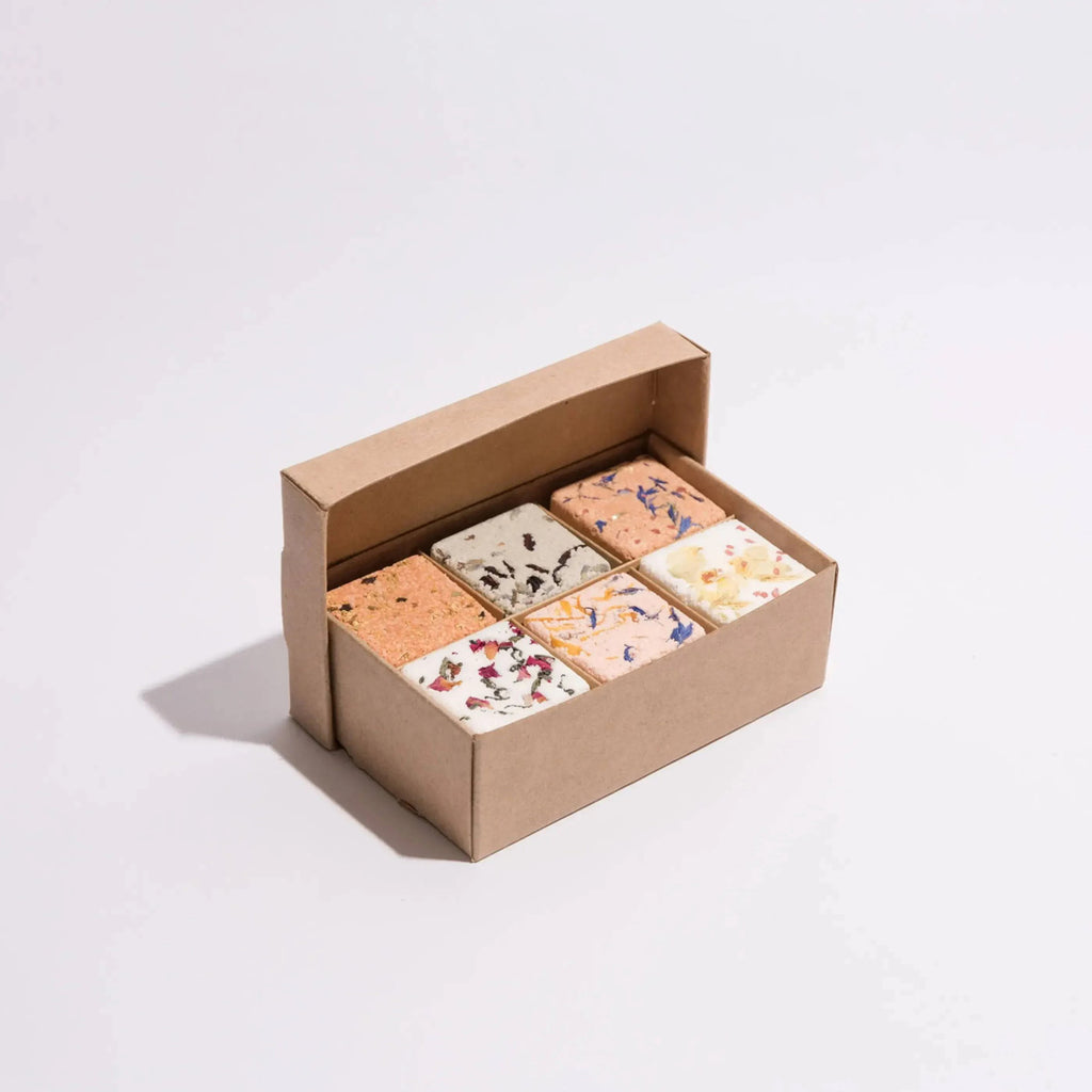 Partially opened box of six bath fizzies on white background