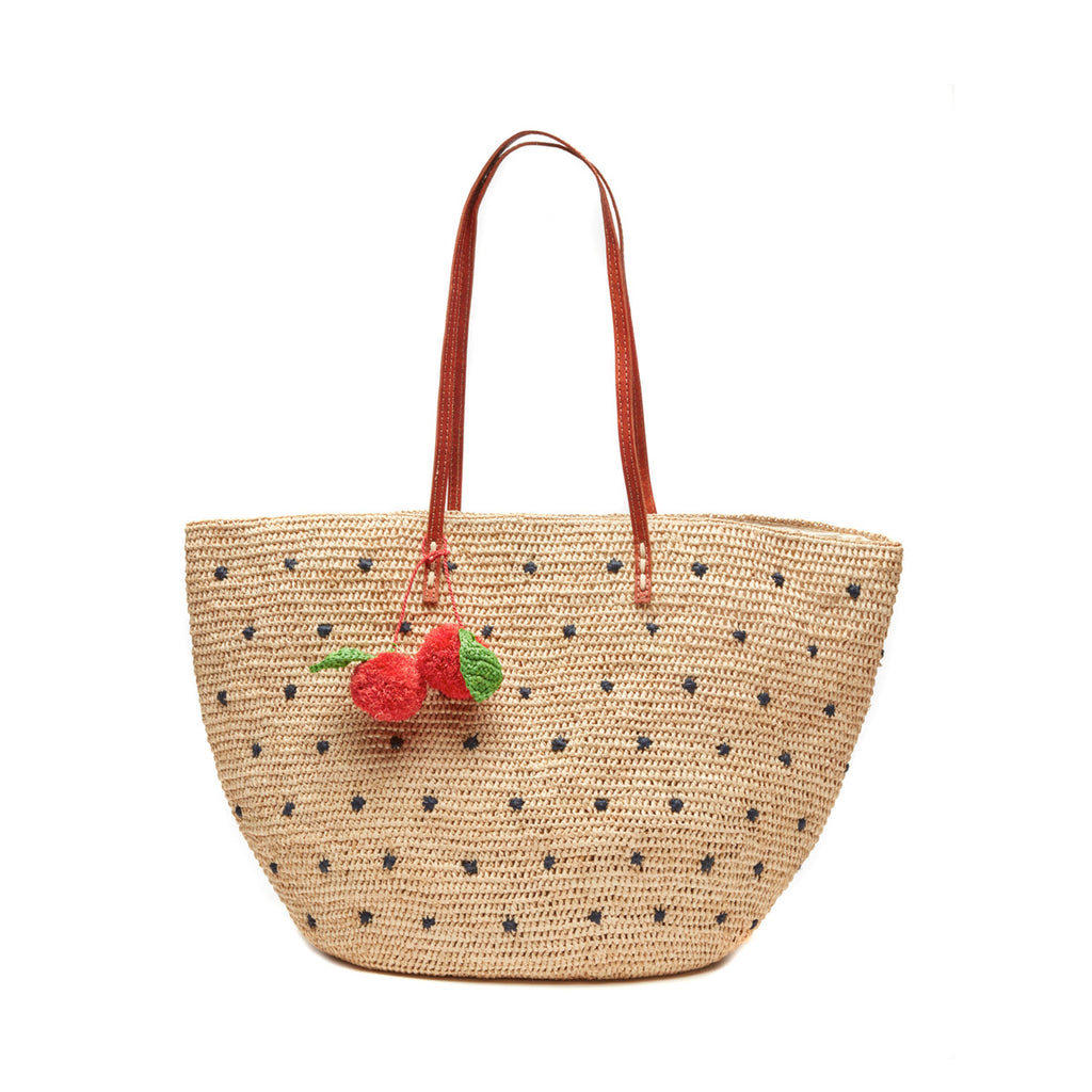 Crocheted raffia tote with cherry poms, navy polka dots, and leather straps