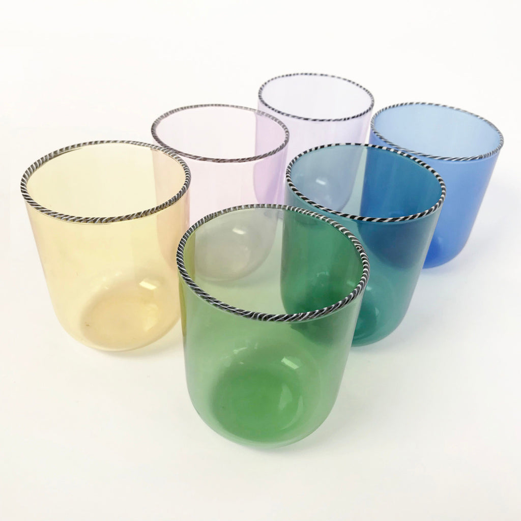 Set of six drinking glasses in rainbow colors on white background