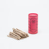 Cedar rope incense in a pile next to it's red tube container