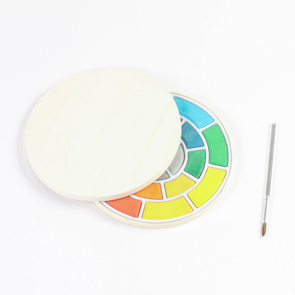 Vibrant water color set in a circular pallet with brush and lid partly on