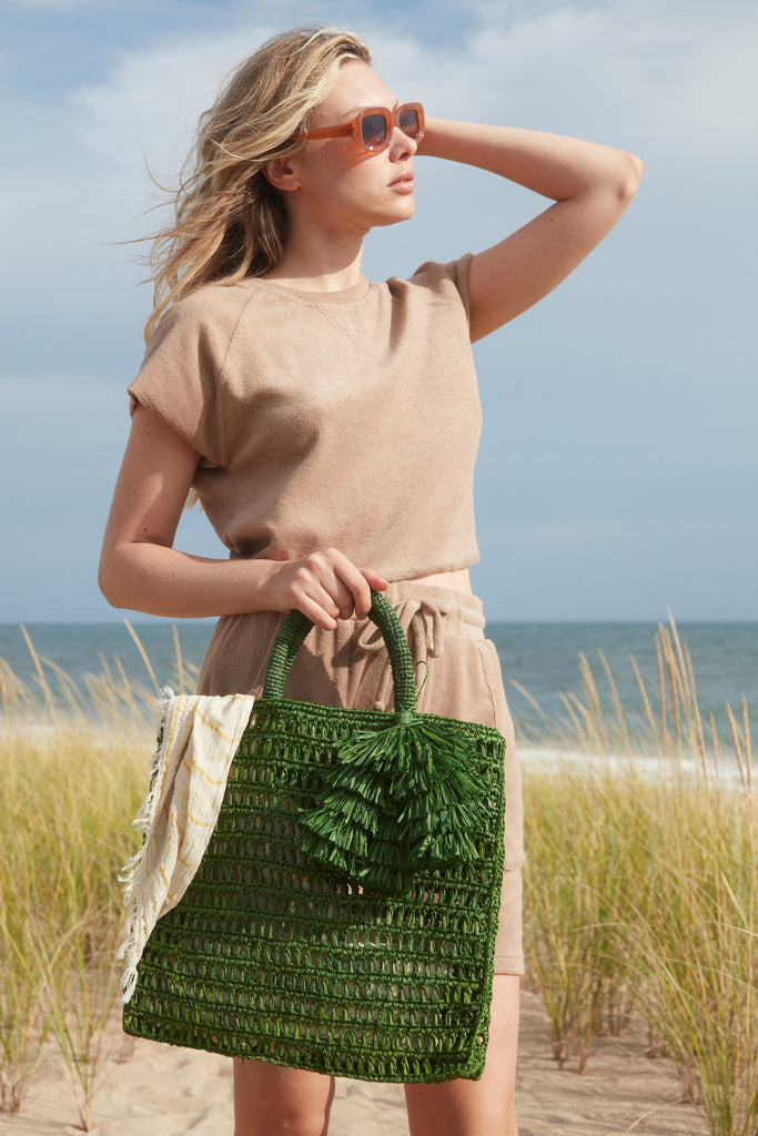 Model on beach wearing Georgia tote in Emerald