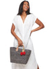 Model on white background in white dress wearing our Hadley woven sisal beach tote in Navy