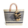Woven sisal basket tote with leather handles and raffia tassels in Natural