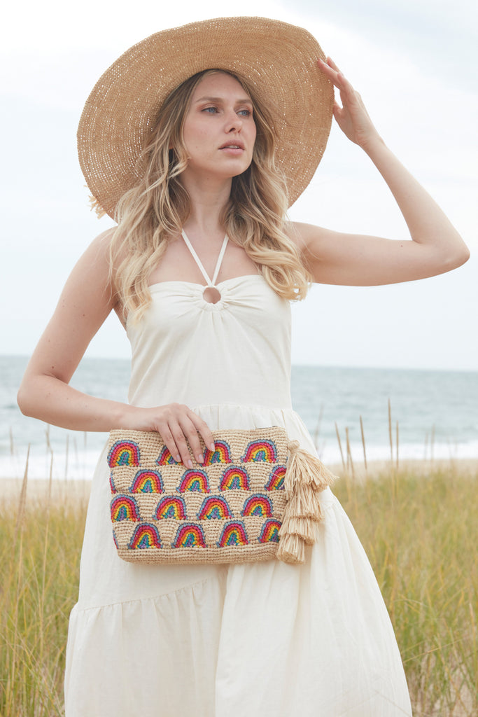 Model holding the Iris clutch in front of the beach
