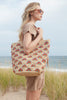 Model on the beach holding our Iris tote