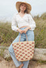 Model holding our Iris tote in front of beach grass