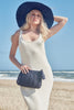 Model on the beach wearing our Jane raffia sun hat in Navy and our Ivy raffia clutch in Navy