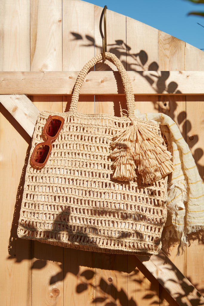 Georgia tote in Natural with sunglasses and a towel on a wooden fence