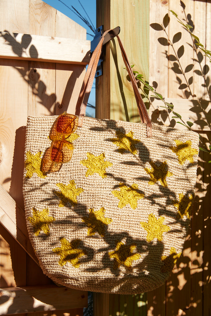 Soleil tote with sunglasses on a wooden deck door