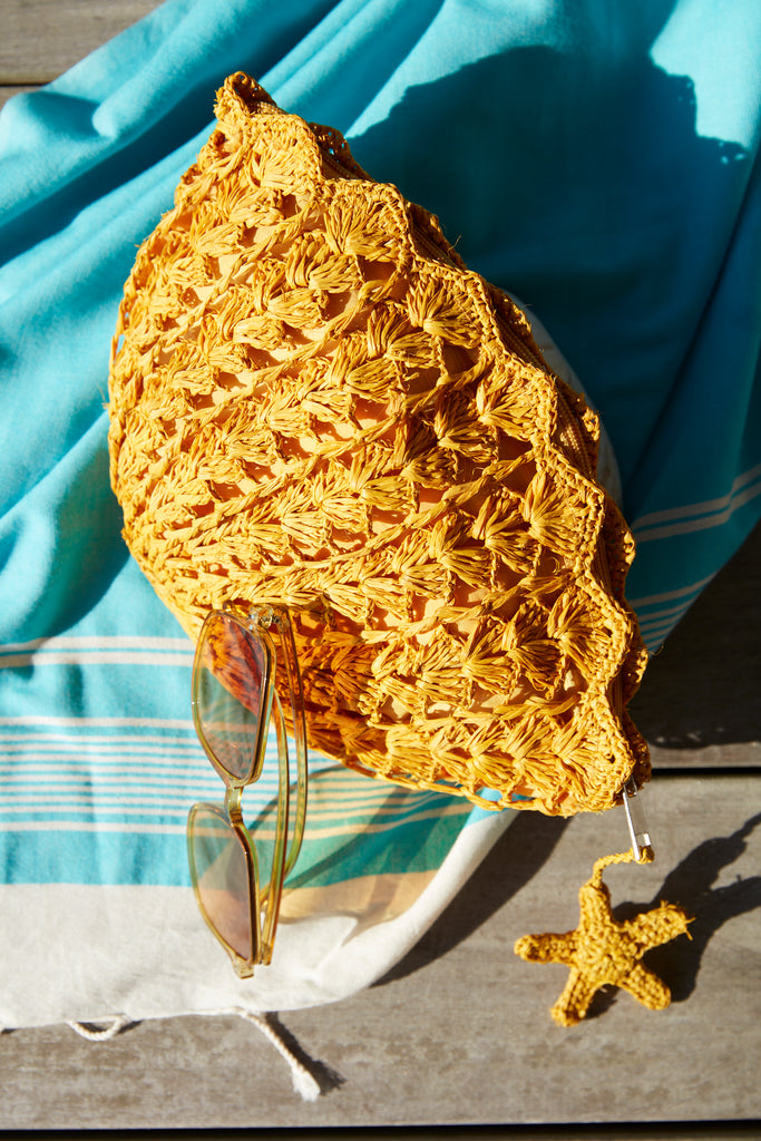 Shelley clutch in Sunflower with sunglasses and a towel