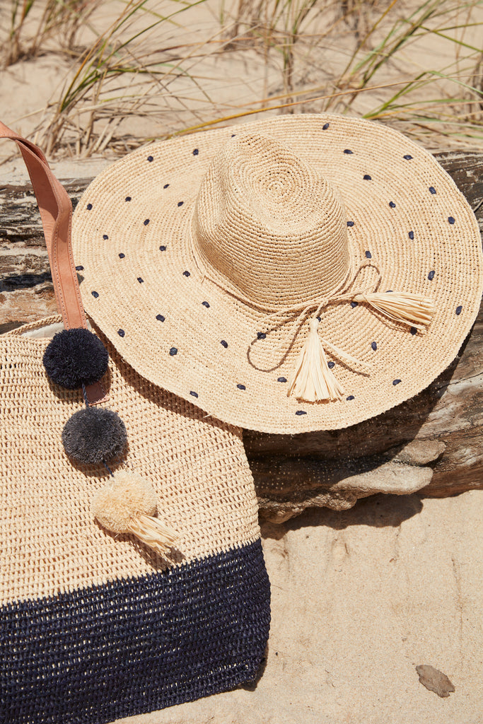 Part of Montauk tote in Navy and Natalia hat in Navy on a beachy log