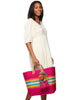 Model on white background holding our La Paz sisal beach tote in Pink